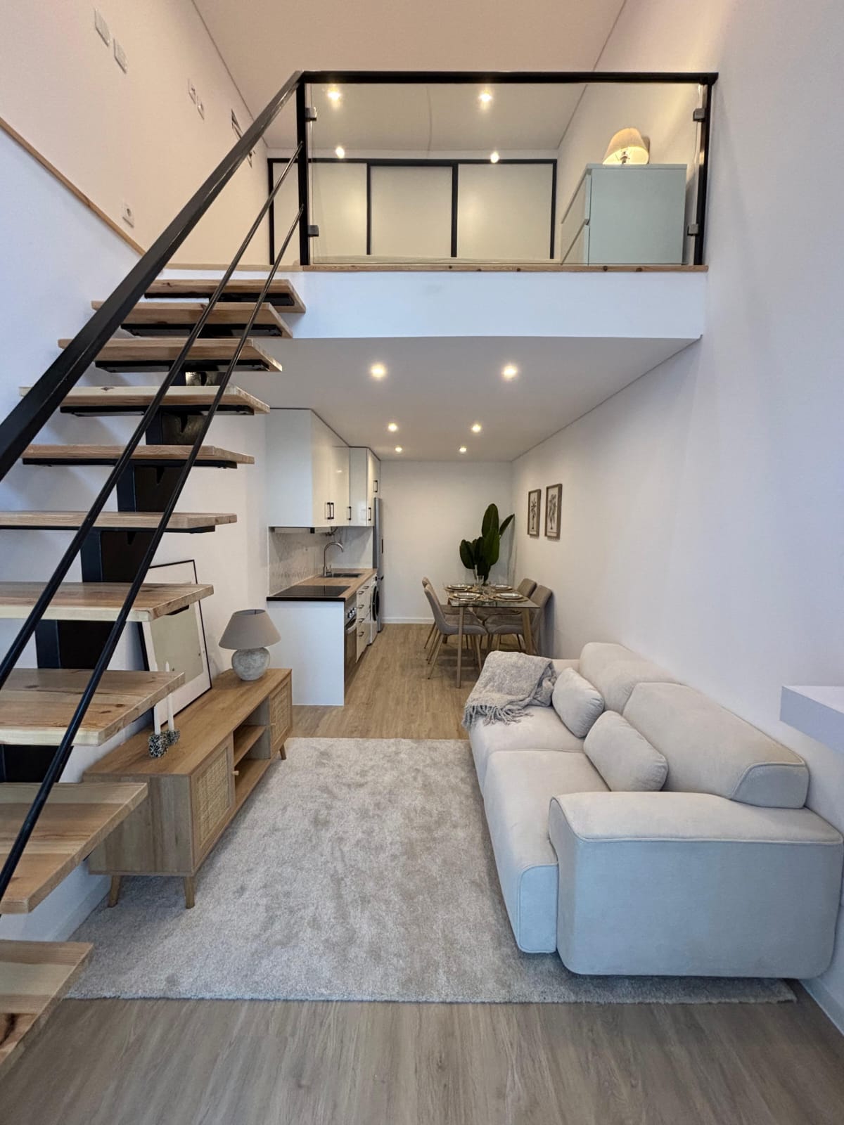 Sala com cozinha e escada para o mezanino