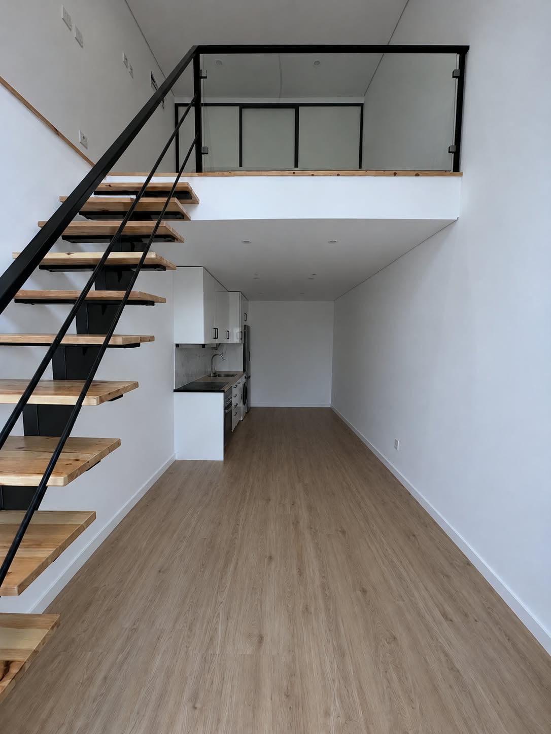 Sala com cozinha e escada para o mezanino